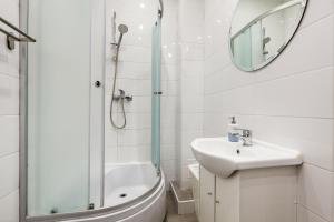 格丁尼亚Prime Home CENTRUM 2的带淋浴、盥洗盆和镜子的浴室