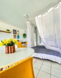 安格拉杜斯雷斯Studio com vista para o mar & Estacionamento Gratuito的一间卧室配有一张带桌子和黄色椅子的床