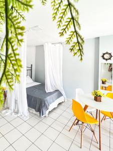 安格拉杜斯雷斯Studio com vista para o mar & Estacionamento Gratuito的卧室配有一张床和一张桌子及椅子