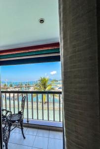 安格拉杜斯雷斯Studio com vista para o mar & Estacionamento Gratuito的阳台配有两把椅子,享有海滩美景