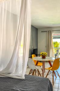 安格拉杜斯雷斯Studio com vista para o mar & Estacionamento Gratuito的一间卧室配有一张床和一张桌子及椅子
