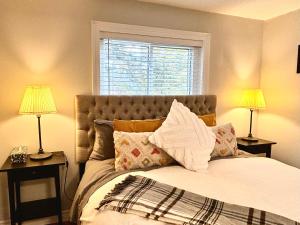 滨湖尼亚加拉Addison House License #041-2021的一间卧室配有一张带两盏灯的床和一扇窗户。