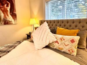 滨湖尼亚加拉Addison House License #041-2021的卧室配有带枕头的床铺和窗户。