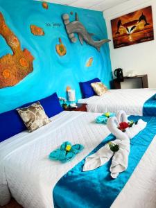 阿约拉港Puerto Ayora Island的一间卧室配有两张带毛巾的床