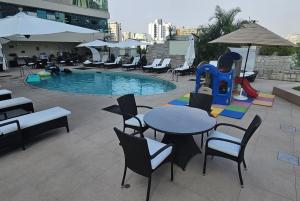 利马海豚会议中心酒店的一个带桌椅的庭院和一个游泳池