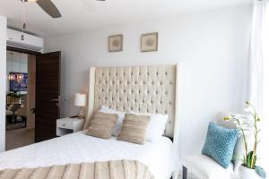 特古西加尔巴Luxury 3BR Penthouse in Astria 1407的白色卧室配有一张白色的大床和一把椅子