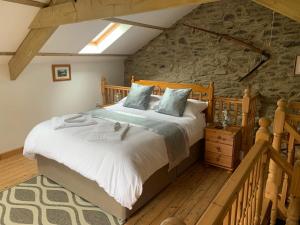阿伯里斯特威斯Tanyresgair Cottages的一间卧室设有一张大床和石墙