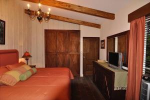 Cabin at Los Titos Coffee Farm的一间卧室配有一张床和一台平面电视