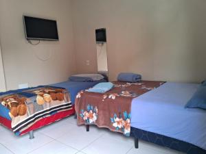 马瑙斯Edward Suíte Manaus 03的两张睡床彼此相邻,位于一个房间里