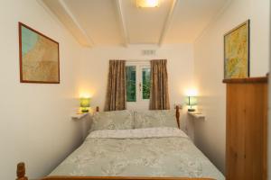 比尔斯韦尔斯Bunny Lodge 30 - Riverside的卧室配有一张床,墙上挂着两盏灯