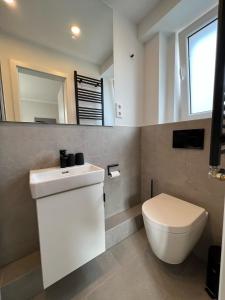 于斯德Dünen Lodge 3的浴室配有白色水槽和卫生间。