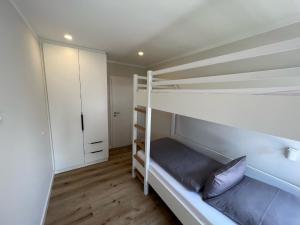 于斯德Dünen Lodge 2的一间卧室配有两张双层床和一个衣柜