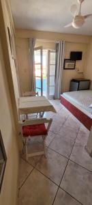 卡波布里奥Suítes Praia Do Foguete的一间设有两张床和一张桌子的房间