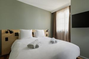 奥尔良La Loge Gogaille - 7 Dormants - Accès autonome的卧室配有白色床和毛巾