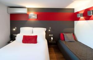 布克凡尔赛贝斯特韦斯特酒店的一间卧室设有一张床和红色及黑色的墙壁