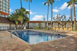 檀香山Best Western The Plaza Hotel - Free Breakfast的一座游泳池,位于酒店,设有椅子和棕榈树