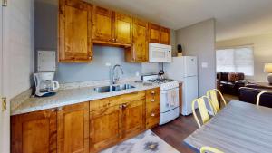 摩押Downtown Cozy Home Base - Purple Sage 3的厨房配有木制橱柜和白色家电