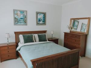 HeathcoteDowning Estate Homestead的一间卧室配有一张带两个梳妆台和镜子的床
