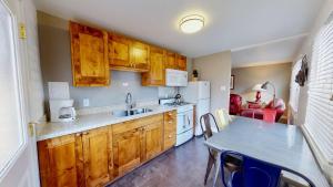 摩押Downtown Cozy Home Base - Purple Sage 5的厨房配有木制橱柜和带水槽的桌子。