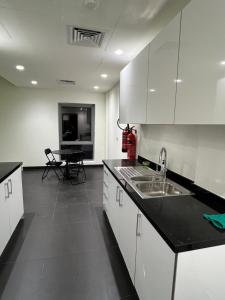 艾恩Lodges的厨房配有白色橱柜、水槽和桌子