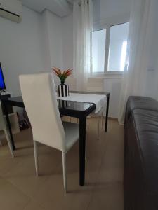 穆尔西亚Hacienda Riquelme Golf Resort Ground Floor Apartment Sucina Murcia的客厅配有餐桌和白色椅子