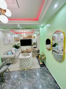 雅温得The Jumeirah Guest Home的客厅设有绿色的墙壁和平面电视。