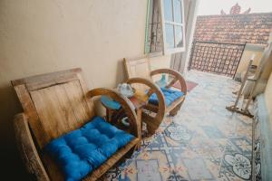 登巴萨萨姆布鲁恩马斯民宿的一间设有两把椅子和一张蓝色座椅的桌子的房间
