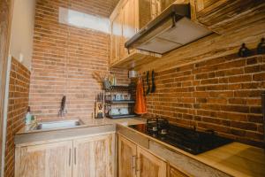 登巴萨萨姆布鲁恩马斯民宿的厨房设有水槽和砖墙