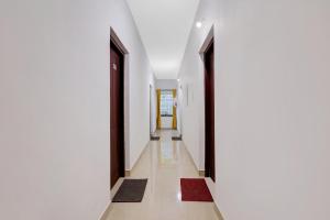 TrippapurCollection O Prashant Stays的走廊上设有白色的墙壁和黑色的门及地毯