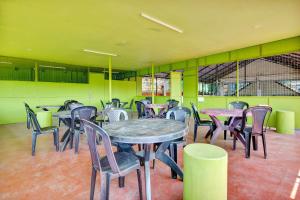TrippapurCollection O Prashant Stays的用餐室设有桌椅和绿色的墙壁