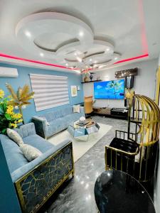 雅温得The Jumeirah Guest Home的带沙发和平面电视的客厅