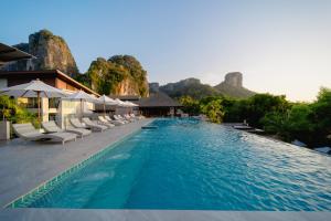 莱利海滩Railay Princess Resort & Spa的一个带椅子的游泳池,背景是山脉