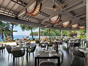 帕皮提Le Tahiti by Pearl Resorts的一间带桌椅的海景餐厅