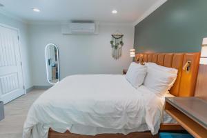 圣玛丽亚Hotel Avanti的卧室配有白色的床和木制床头板