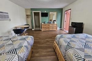 皮尔斯堡Rodeway Inn Fort Pierce US Highway 1的酒店客房设有两张床和一张桌子。