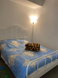 多伦多Cozy holiday home的一张带蓝棉被的床,上面有豹子枕头