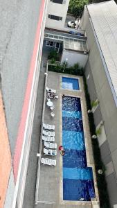 圣保罗Completo, moderno e bem localizado na Rua do Metrô Brás SP的享有带躺椅的游泳池的顶部景致