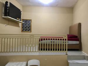 LamonganGrand Hagawa Syariah near Alun Alun Lamongan RedPartner的一间小房间,配有婴儿床和电视