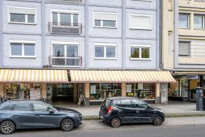 科布伦茨NEU: 100m² - ideal für Familien/Geschäftsr. - HBF的两辆汽车停在大楼前