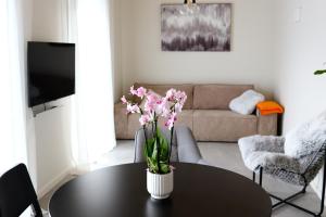 斯伽尔达Tūristu apartamenti的客厅里设有一张桌子,上面有花瓶