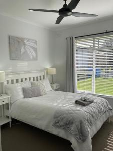 芒特甘比尔Rosa's Apartment的白色卧室配有床和吊扇