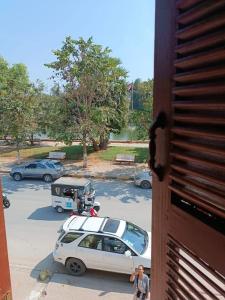 马德望top loft battambang的站在停车场的白色汽车旁的人