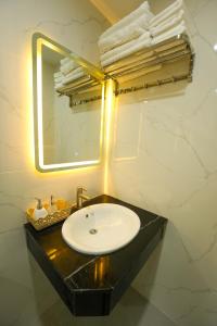 归仁Gia Kiên Hotel的浴室配有盥洗盆、镜子和毛巾