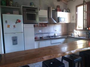 San RoqueCASONA PINTORESCA en las sierras的厨房配有白色家电和木制台面