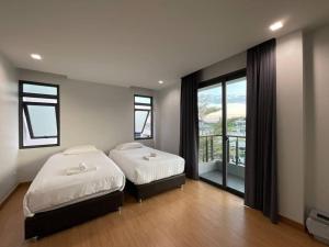 清迈65 hostel chiangmai的一间带两张床的卧室和一个阳台