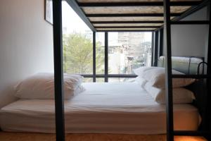 台北瀚寓夏天 Hanns Summer的窗户客房内的一张带白色枕头的床