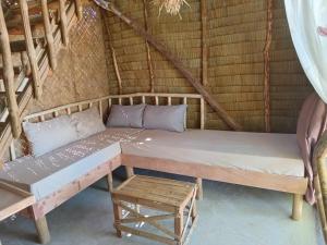 爱妮岛BICE Camp Bucana Beach的房间里的一张床位和一张桌子