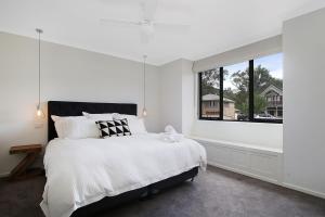 布赖特Alpine Knights Stylish Luxury的白色的卧室设有一张大床和一个窗户