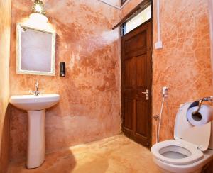 蒙巴萨Tulia Old Town的一间带卫生间、水槽和门的浴室