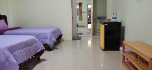 甲米镇甲米棕榈考维度假村的一间医院间,配有两张床和一张桌子